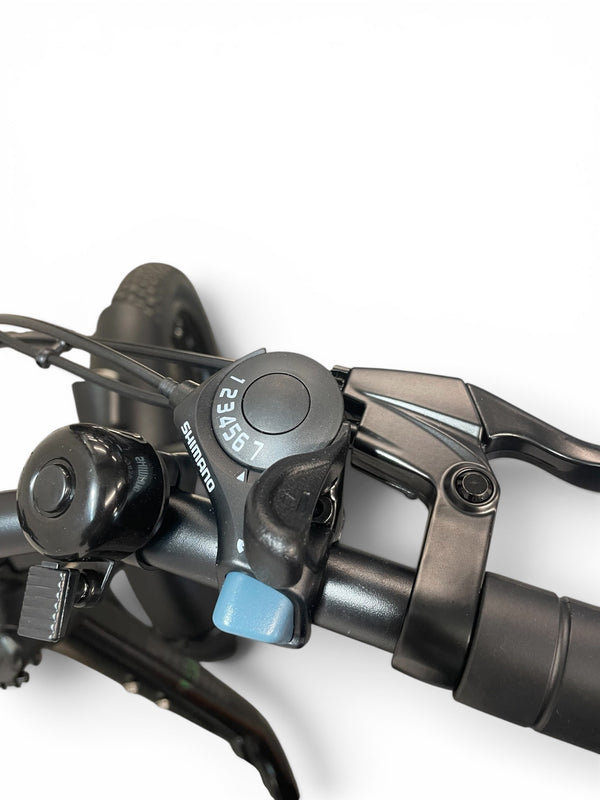 Close-up of a bicycle handlebar area showing a black Shimano shifter lever with a light blue button and black brake lever on a white background.